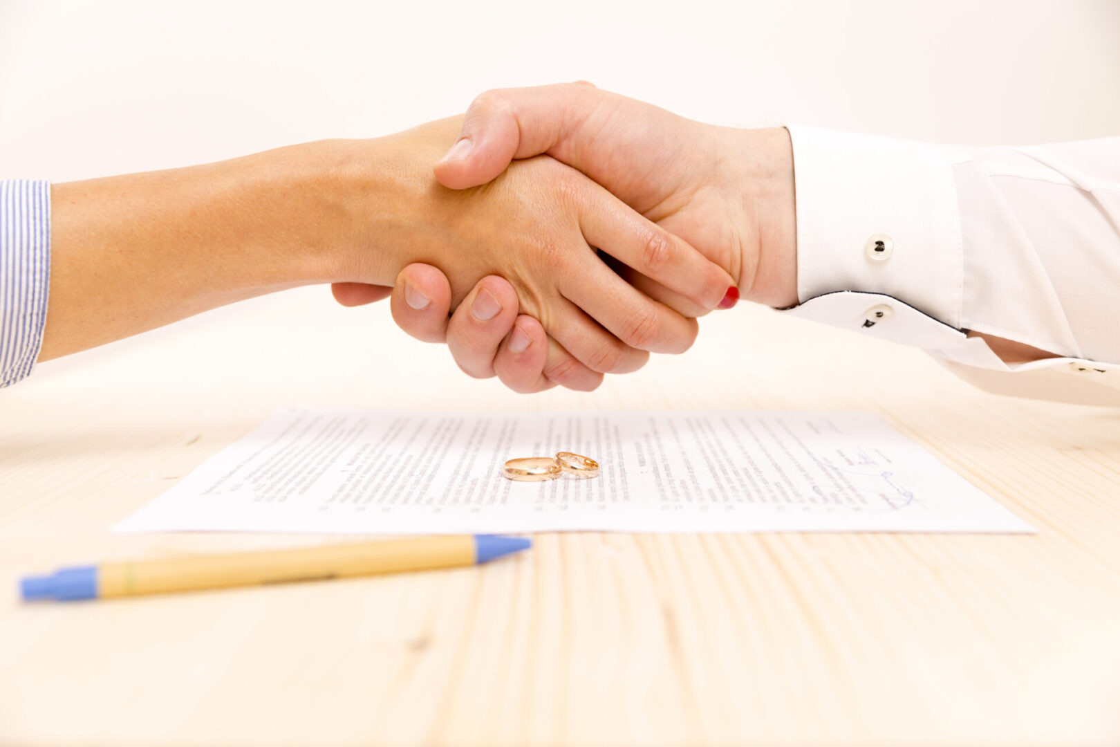 Closeup of a young man an a young woman signing a prenuptial agreement